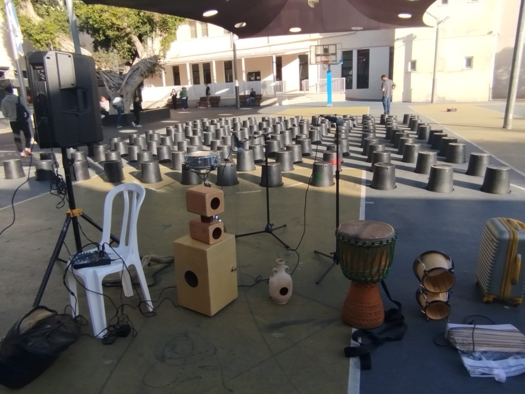 סדנת תיפוף במגרש — דליים, תופים וציוד הגברה